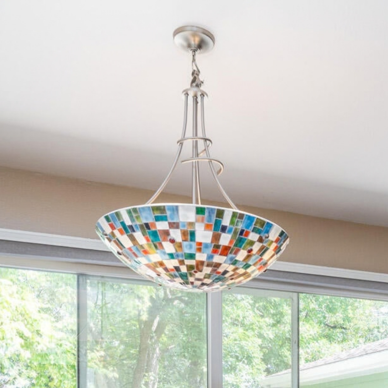 Stained glass pendant light hanging over the dining room table