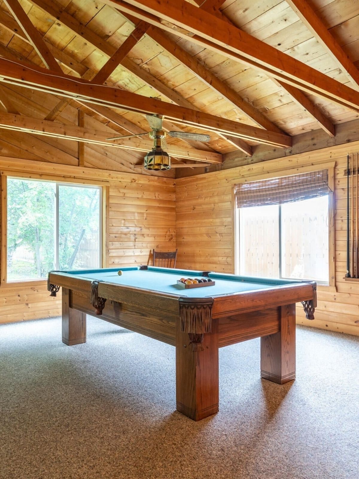 Pool table in a knotty pine room with a vaulted wood-beam ceiling, in the Crookston house